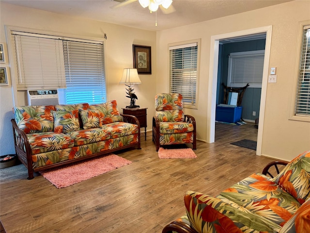 living room with cooling unit, hardwood / wood-style flooring, and ceiling fan