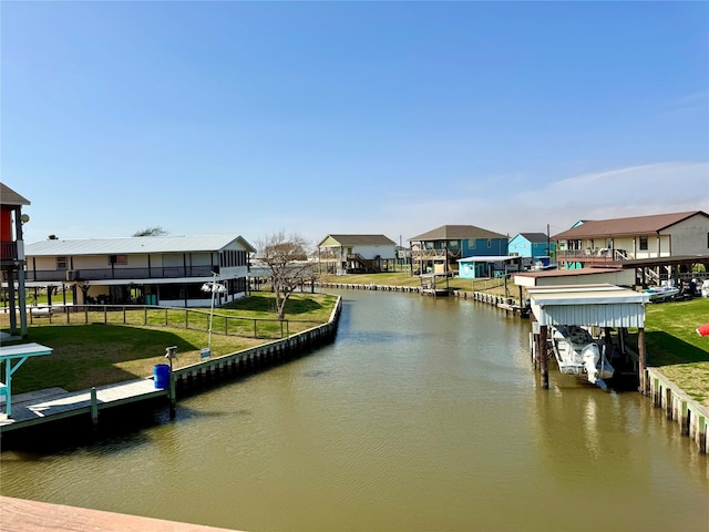 dock area with a water view and a yard