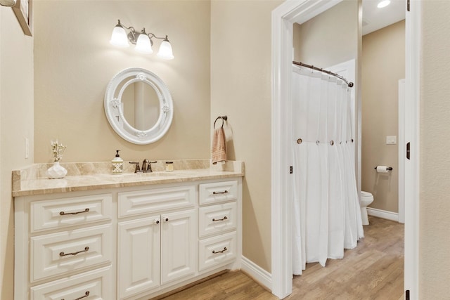 bathroom featuring vanity, hardwood / wood-style floors, and toilet