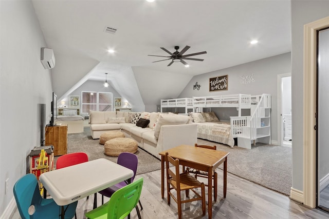 interior space featuring lofted ceiling, light hardwood / wood-style flooring, and an AC wall unit