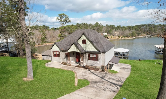 french provincial home with a dock, a front yard, and a water view