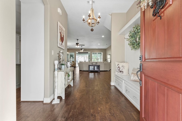 foyer entrance with ceiling fan with notable chandelier and dark hardwood / wood-style floors