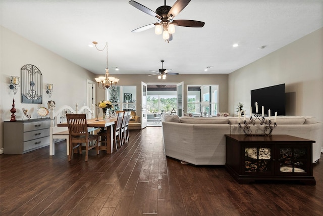 living room with dark hardwood / wood-style flooring and ceiling fan with notable chandelier