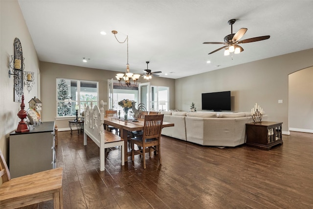 dining space featuring dark hardwood / wood-style floors and ceiling fan with notable chandelier