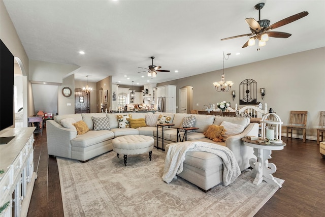 living room with wood-type flooring and ceiling fan with notable chandelier