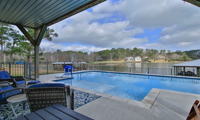 view of swimming pool featuring a water view and a patio