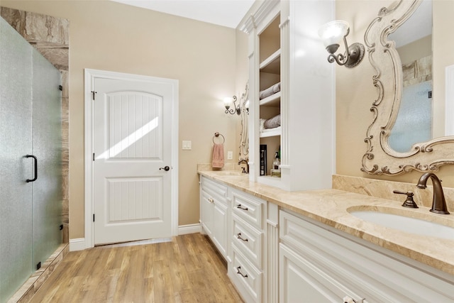 bathroom with wood-type flooring, vanity, and a shower with shower door