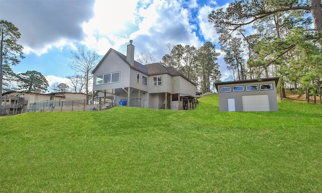 back of property featuring an outbuilding, a garage, and a lawn