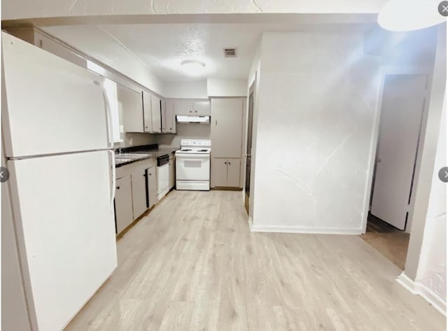 kitchen with white appliances, visible vents, light wood-style flooring, a textured ceiling, and under cabinet range hood