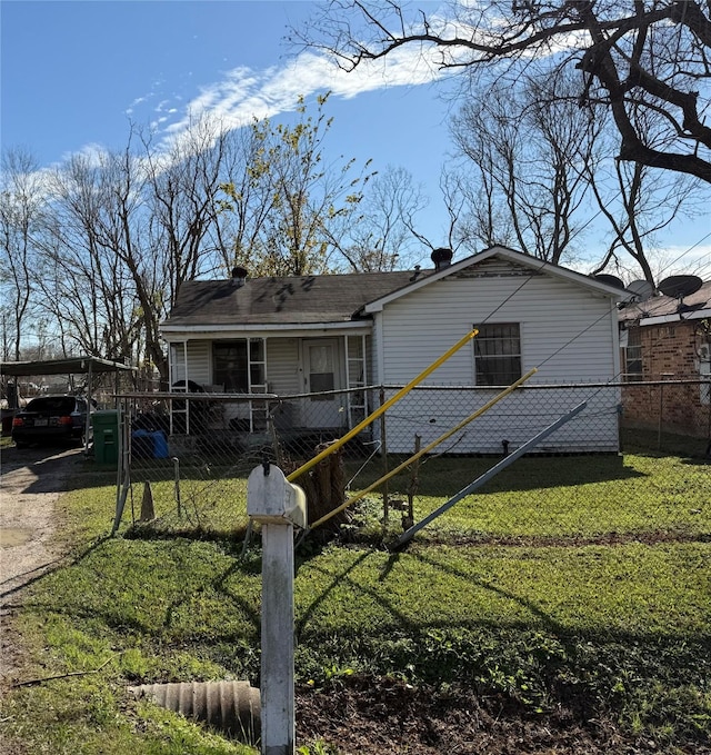 view of front of home with driveway, a fenced front yard, a front lawn, and an attached carport