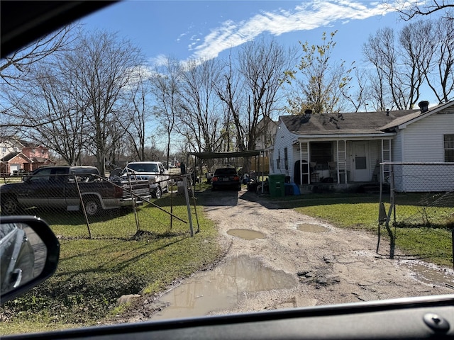 exterior space featuring dirt driveway and fence