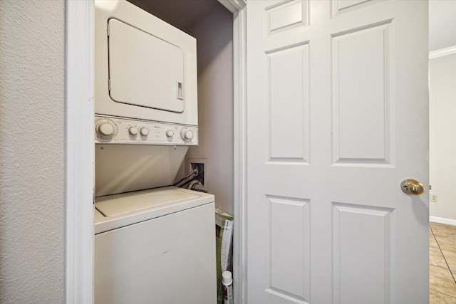 laundry area featuring light tile patterned flooring and stacked washer / dryer