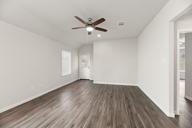 spare room with a healthy amount of sunlight, baseboards, visible vents, and dark wood-type flooring