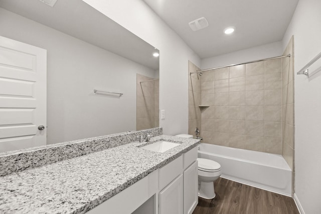 bathroom featuring visible vents, toilet, wood finished floors, bathtub / shower combination, and vanity