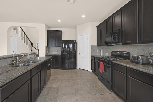 kitchen with sink, light tile patterned floors, tasteful backsplash, black appliances, and stone countertops