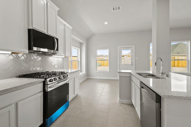 kitchen featuring white cabinetry, sink, light stone counters, and appliances with stainless steel finishes