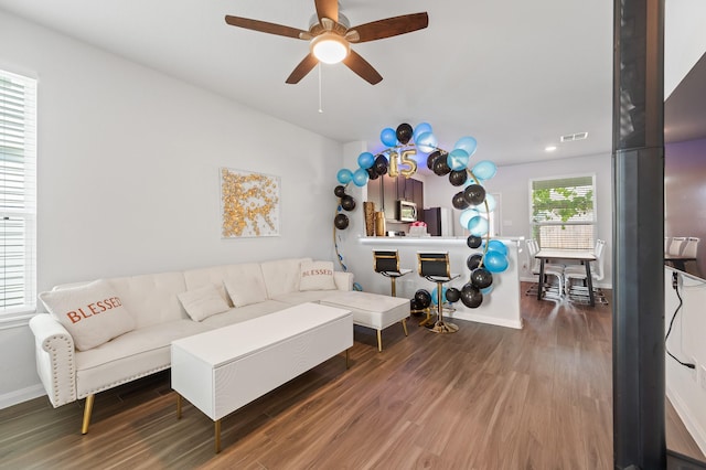 living room with ceiling fan and dark hardwood / wood-style flooring