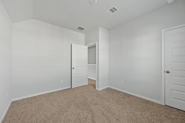 unfurnished bedroom with vaulted ceiling and carpet