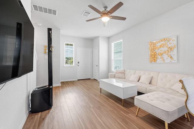 living room with ceiling fan and light hardwood / wood-style flooring