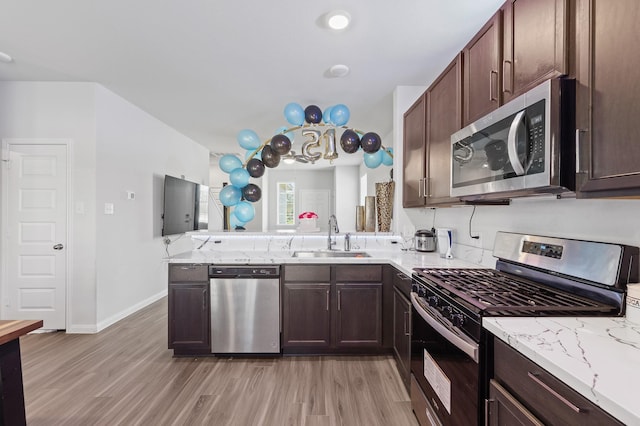 kitchen with light hardwood / wood-style flooring, sink, dark brown cabinets, and appliances with stainless steel finishes