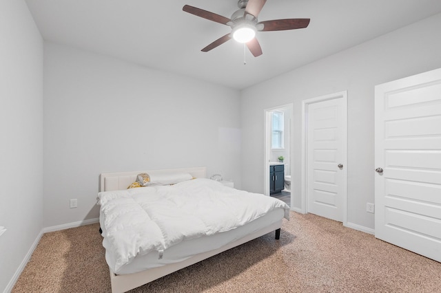 bedroom with ensuite bath, ceiling fan, and carpet flooring