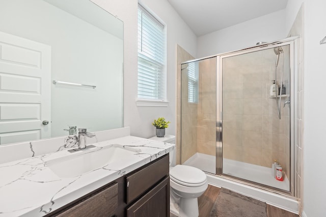 bathroom with vanity, toilet, an enclosed shower, and wood-type flooring