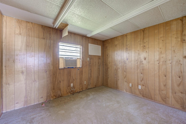 empty room featuring cooling unit, wood walls, and carpet