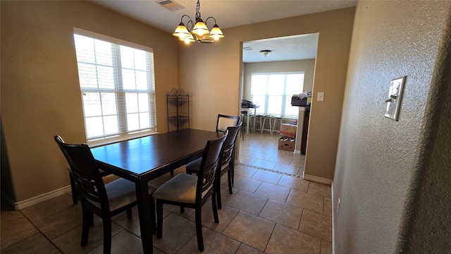 tiled dining space featuring an inviting chandelier