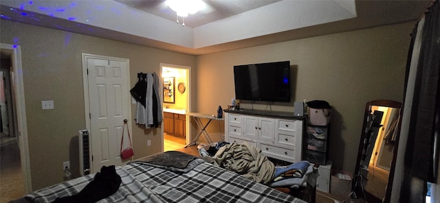 bedroom featuring ensuite bathroom and a tray ceiling