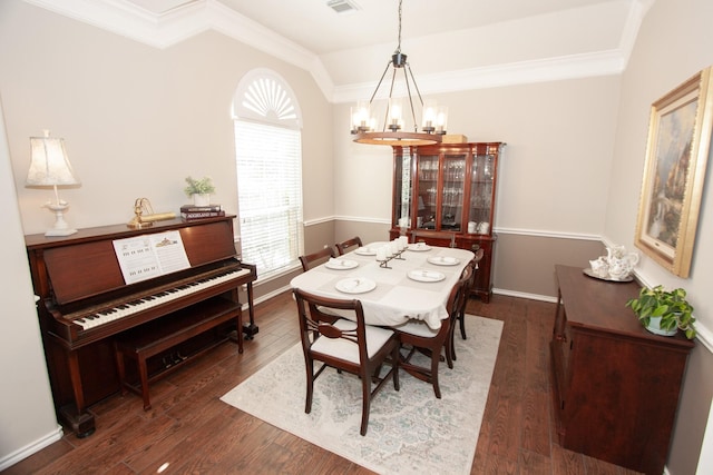 dining room with crown molding, dark hardwood / wood-style floors, and a chandelier