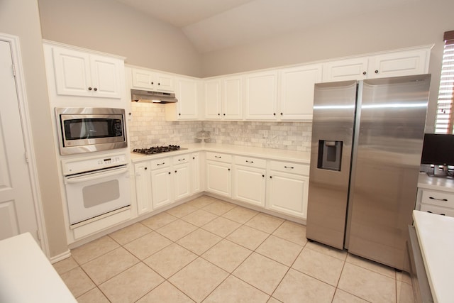 kitchen featuring stainless steel appliances, white cabinetry, lofted ceiling, and tasteful backsplash