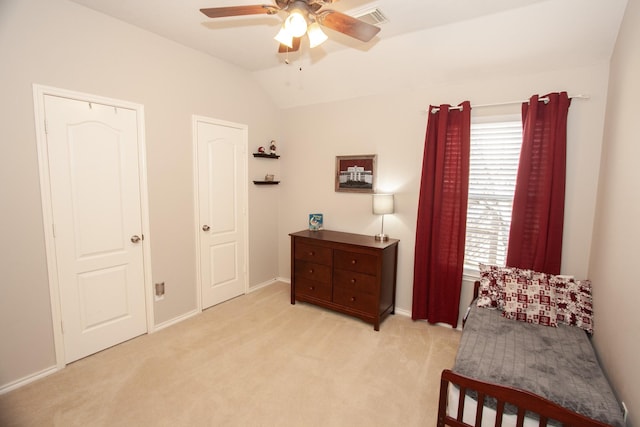 bedroom with ceiling fan, vaulted ceiling, and light carpet