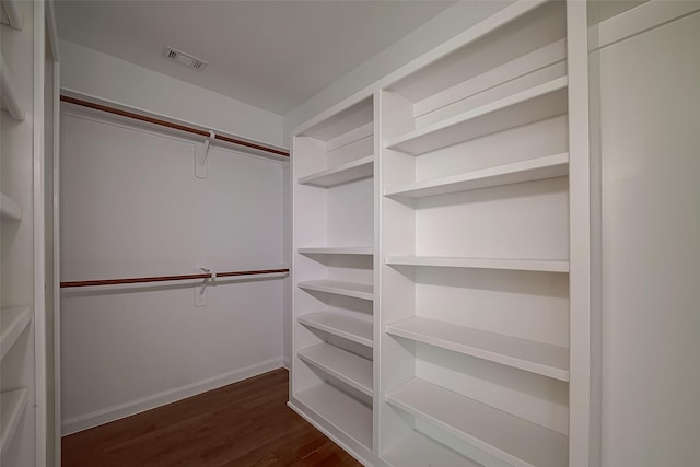 spacious closet with dark wood-type flooring