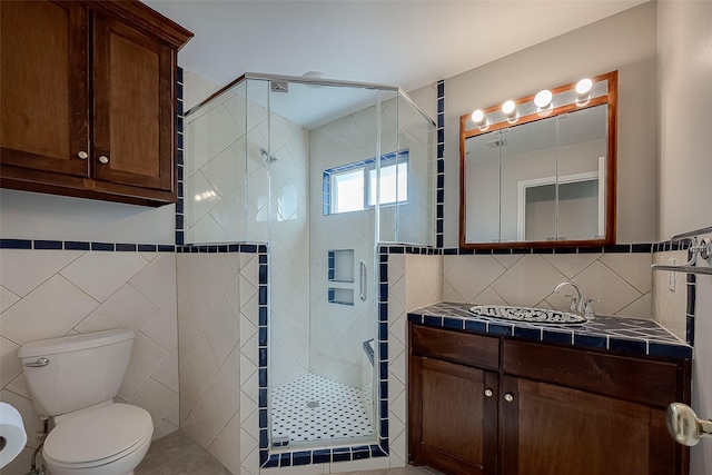 bathroom with vanity, tile walls, an enclosed shower, and toilet