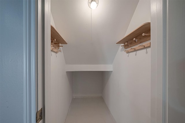 walk in closet with light tile patterned flooring and lofted ceiling