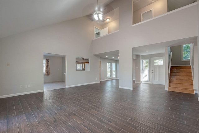 unfurnished living room with ceiling fan, dark hardwood / wood-style flooring, and high vaulted ceiling