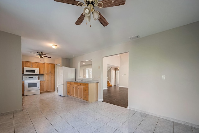 kitchen with sink, white appliances, ceiling fan, and light tile patterned flooring