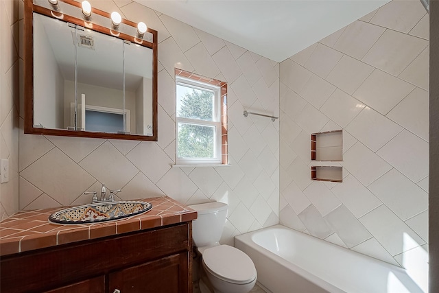 bathroom featuring a washtub, tile walls, vanity, tasteful backsplash, and toilet