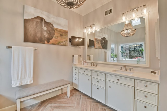 bathroom with vanity, parquet flooring, and an inviting chandelier