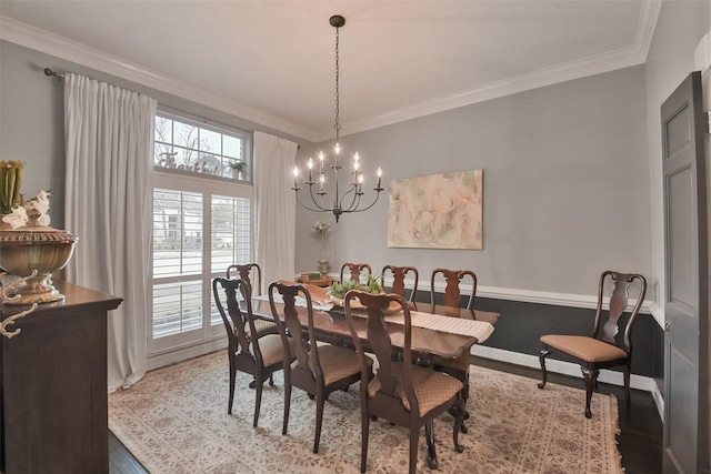 dining space featuring ornamental molding, a notable chandelier, and light wood-type flooring