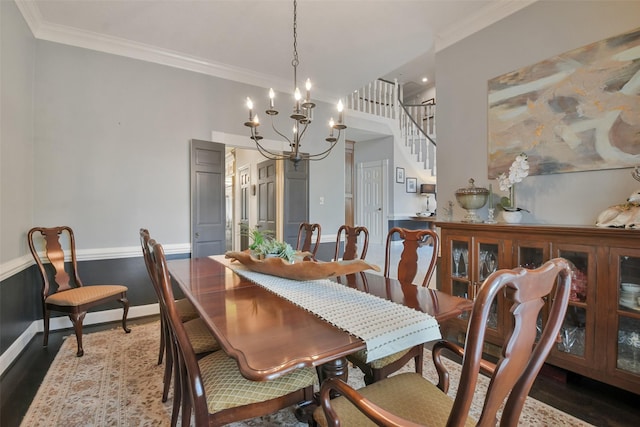 dining room featuring dark hardwood / wood-style flooring, crown molding, and a chandelier