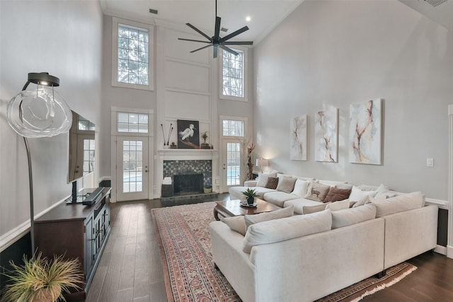 living room featuring a high end fireplace, dark hardwood / wood-style floors, and plenty of natural light