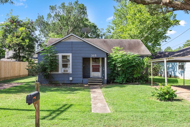 bungalow-style home featuring cooling unit and a front lawn