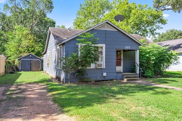 bungalow-style home with a front lawn and a shed