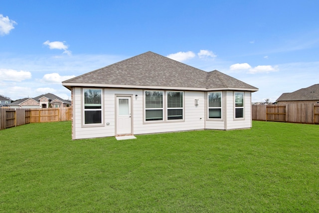 rear view of property featuring a lawn