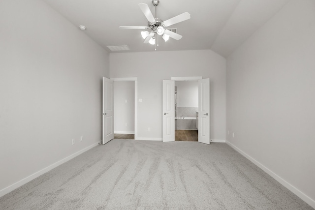 unfurnished bedroom with ensuite bathroom, lofted ceiling, carpet floors, and ceiling fan