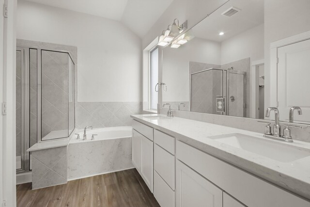 bathroom featuring lofted ceiling, vanity, hardwood / wood-style flooring, and independent shower and bath