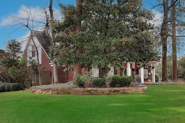 view of property hidden behind natural elements with a front lawn