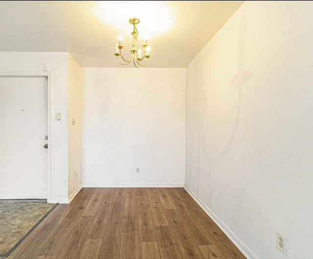 unfurnished dining area featuring dark hardwood / wood-style floors and a chandelier