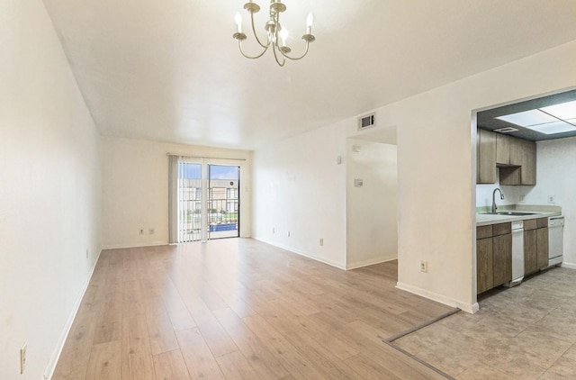 unfurnished living room featuring sink, an inviting chandelier, and light hardwood / wood-style floors